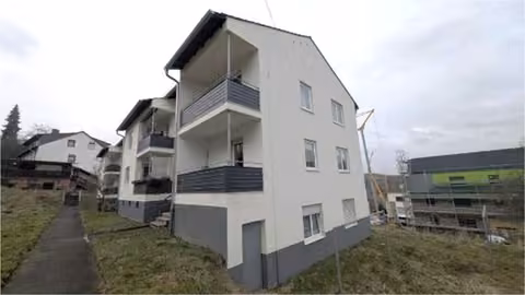 Zwangsversteigerung Eigentumswohnung in Aarbergen, Michelbach – Gepflegte Au%enansicht des Mehrfamilienhauses mit Balkonstrukturen.