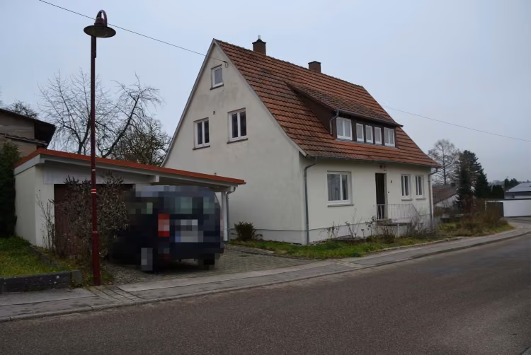 Zwangsversteigerung Einfamilienhaus in Frankenhardt, Gründelhardt – Westansicht des Anwesens mit Garage und Straßenzug.