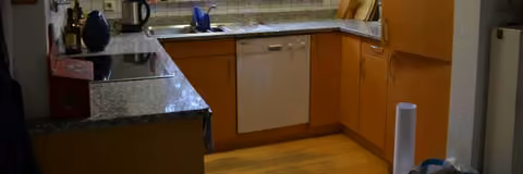 Zwangsversteigerung Einfamilienhaus in Frankenhardt, Gründelhardt – Wohnzimmer im Erdgeschoss mit stillgelegtem Kachelofen.