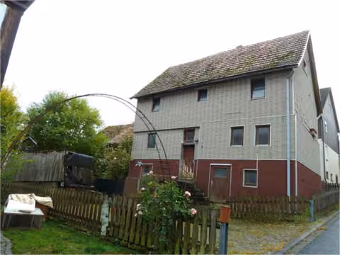 Zwangsversteigerung Einfamilienhaus in Rotenburg a.d. Fulda, Erkshausen – Vorderansicht des unbewohnten Wohnhauses Heideweg 9 mit Treppenaufgang.