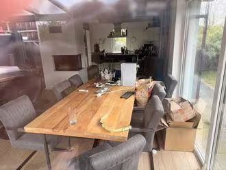 Zwangsversteigerung Einfamilienhaus in Ibbenbüren – Blick durch die Fensterscheibe in den möblierten Essbereich des Hauses.