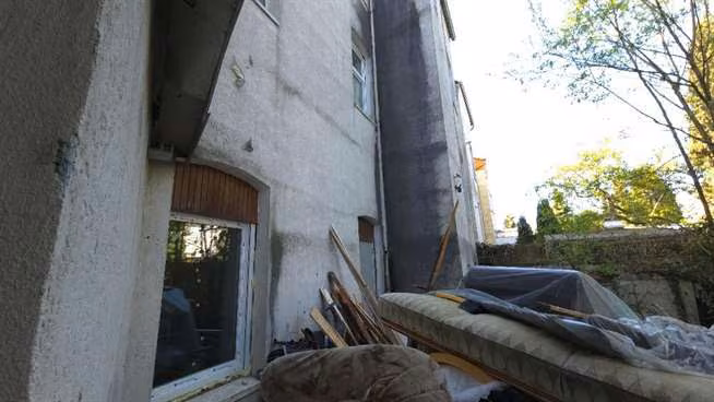 Zwangsversteigerung Eigentumswohnung in Gelsenkirchen, Rotthausen – Rückwärtige, schadhafte Hoffassade des Gebäudes mit deutlichen Feuchtigkeitsspuren.