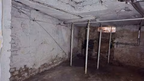 Zwangsversteigerung Eigentumswohnung in Gelsenkirchen, Rotthausen – Kellerraum mit den statisch notwendigen Deckenstützen und Feuchtigkeitsschäden.