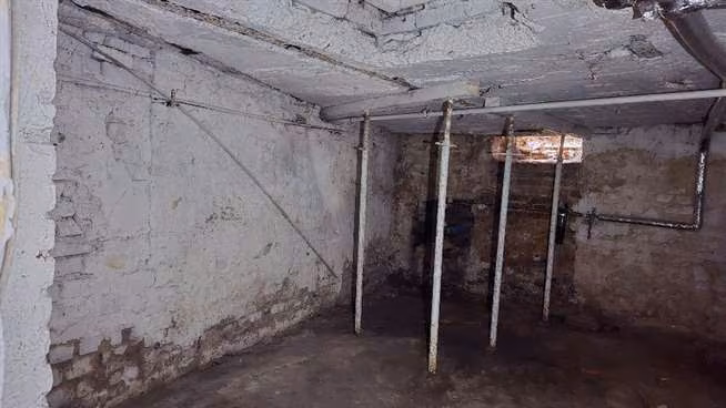 Zwangsversteigerung Eigentumswohnung in Gelsenkirchen, Rotthausen – Kellerraum mit den statisch notwendigen Deckenstützen und Feuchtigkeitsschäden.