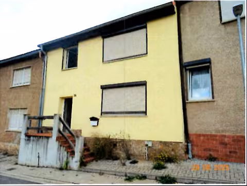 Zwangsversteigerung Einfamilienhaus in Hettstedt, Molmeck – Vorderansicht des Einfamilienhauses mit dem charakteristischen Treppenaufgang.