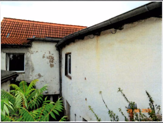 Zwangsversteigerung Einfamilienhaus in Hettstedt, Molmeck – Perspektivische Straßenansicht des beidseitig angebauten Wohnhauses.