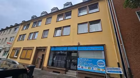 Zwangsversteigerung Büro in Gelsenkirchen, Schalke – Straßenseitige Außenansicht des Wohn- und Geschäftshauses mit dem Ladenlokal im EG rechts.