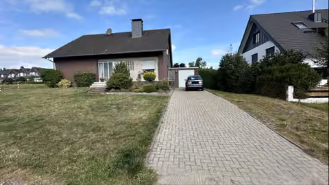 Zwangsversteigerung Einfamilienhaus in Dinslaken, Oberlohberg – Sd-Ansicht des freistehenden Einfamilienhauses mit der gepflasterten Garagenzufahrt.