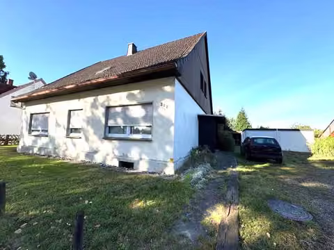 Zwangsversteigerung Zweifamilienhaus in Löhne, Mennighüffen – Nordansicht des Giebels und des Anbaus.