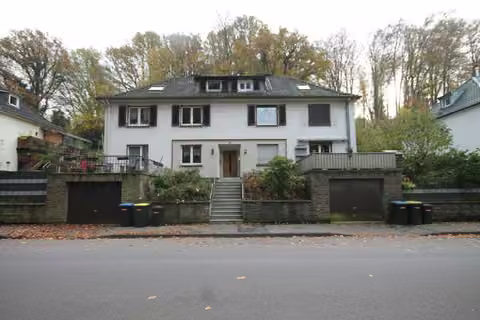 Zwangsversteigerung Mehrfamilienhaus in Solingen, Wald – Gebäudeansicht von Nordwesten mit den vorgelagerten Garagen von der Ittertalstraße aus.