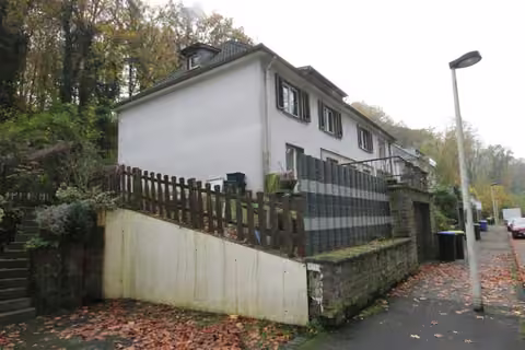 Zwangsversteigerung Mehrfamilienhaus in Solingen, Wald – Gebäudeansicht von Norden mit Einfriedung und seitlicher Ansicht.