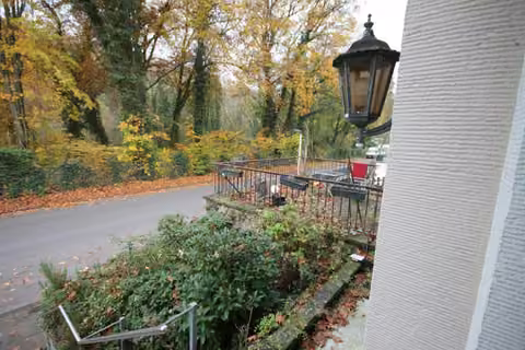 Zwangsversteigerung Mehrfamilienhaus in Solingen, Wald – Vorgarten und Terrassenbereich über der Garage des Sondereigentums.