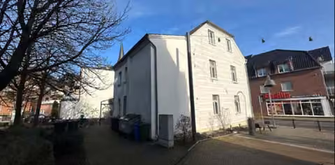 Zwangsversteigerung Büro in Alpen – Seitenansicht des historischen Gebäudes von Süden.