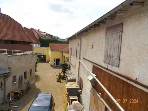 Zwangsversteigerung Mehrfamilienhaus in Sangerhausen – Außenansicht des bebauten Grundstücks mit Wohnhaus und Nebengebäuden vom Hof aus.