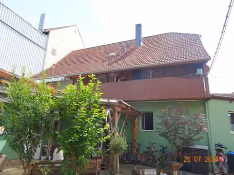 Zwangsversteigerung Mehrfamilienhaus in Sangerhausen – Seitenansicht der Nebengebäude (Scheune und Garage) auf dem Hofgelände.