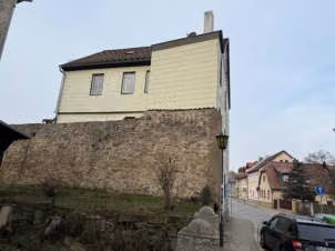 Zwangsversteigerung Mehrfamilienhaus in Saalfeld – Rückansicht des Objektes mit der historischen Stadtmauer.