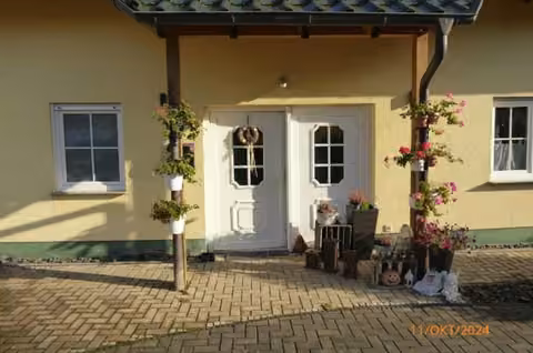 Zwangsversteigerung Einfamilienhaus in Stadtallendorf, Erksdorf – Nahaufnahme des überdachten Hauseingangsbereichs.