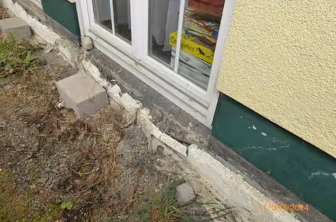 Zwangsversteigerung Einfamilienhaus in Stadtallendorf, Erksdorf – Schadhafter Sockelbereich an der nordöstlichen Traufwand.