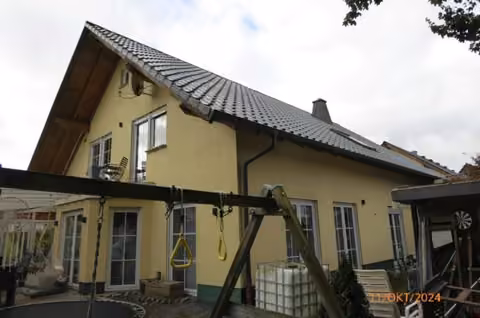 Zwangsversteigerung Einfamilienhaus in Stadtallendorf, Erksdorf – Gartenansicht mit der nicht genehmigten Terrassenüberdachung.
