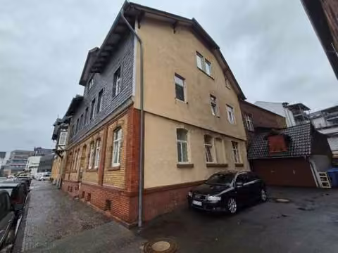 Zwangsversteigerung Mehrfamilienhaus in Biedenkopf, Stadtkern – Seitliche Ansicht des Mehrfamilienhauses mit Zufahrtsbereich.