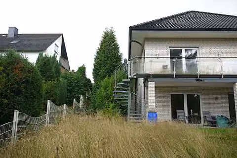 Zwangsversteigerung Zweifamilienhaus in Herford, Eickum – Rückseitige Ansicht der Nord-Ostseite mit Balkon und Gartenbereich.