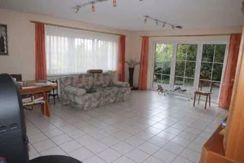 Zwangsversteigerung Einfamilienhaus in Amberg – Großzügiges, hell gefliestes Wohnzimmer mit Zugang zur Terrasse.