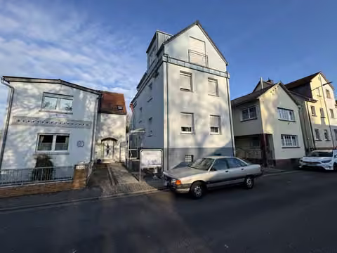 Zwangsversteigerung Einfamilienhaus in Schöneck, Büdesheim – Straßenansicht der Mühlstraße mit dem Versteigerungsobjekt und Nachbarbebauung.