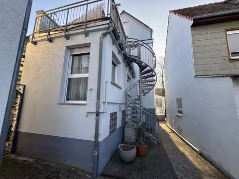 Zwangsversteigerung Einfamilienhaus in Schöneck, Büdesheim – Ansicht des rückwärtigen Anbaus mit der stählernen Spindeltreppe zur Dachterrasse.