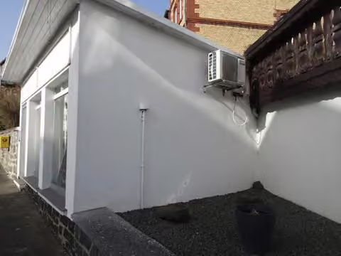 Zwangsversteigerung Grundstück in Gladenbach, Weidenhausen – Südostansicht des Gebäudes mit der außen montierten Klimaanlage des Mieters.
