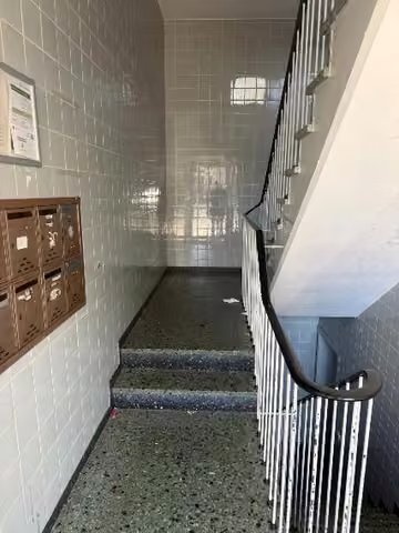 Zwangsversteigerung Mehrfamilienhaus in Essen, Huttrop – Innenansicht des Treppenhauses mit Kunststeinabdeckung und typischem 1960er-Jahre-Geländer.