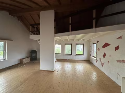 Zwangsversteigerung Eigentumswohnung in Hürtgenwald, Vossenack – Großes Wohn- und Schlafzimmer im Dachgeschoss mit Holzdecke.