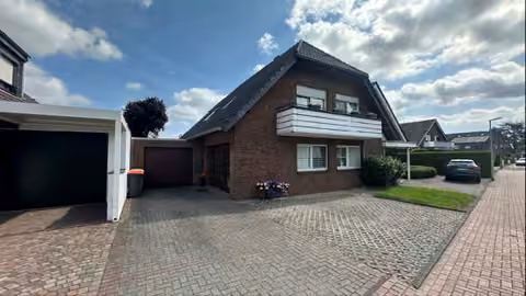 Zwangsversteigerung Mehrfamilienhaus in Dinslaken, Oberlohberg – West-Ansicht des gepflegten Zweifamilienhauses mit gepflasterter Vorfläche.