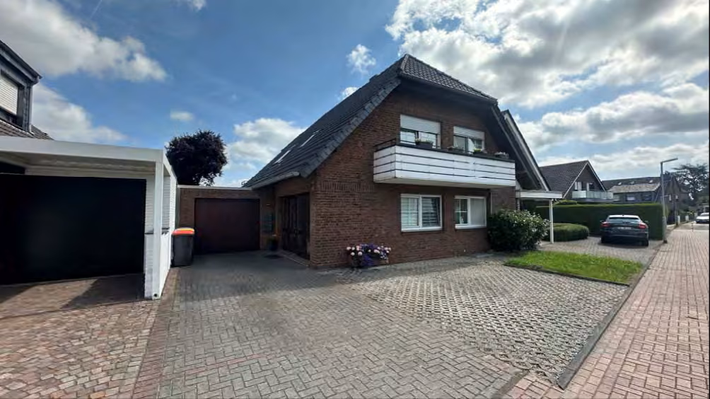 Zwangsversteigerung Mehrfamilienhaus in Dinslaken, Oberlohberg – West-Ansicht des gepflegten Zweifamilienhauses mit gepflasterter Vorfläche.