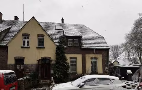 Zwangsversteigerung Einfamilienhaus in Duisburg, Neumühl – Vorderansicht der Doppelhaushälfte bei Schneefall.