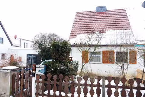 Zwangsversteigerung Einfamilienhaus in Großneuhausen – Vorderhaus - Südostansicht der weißen Putzfassade mit braunen Holzfensterläden im Schnee.