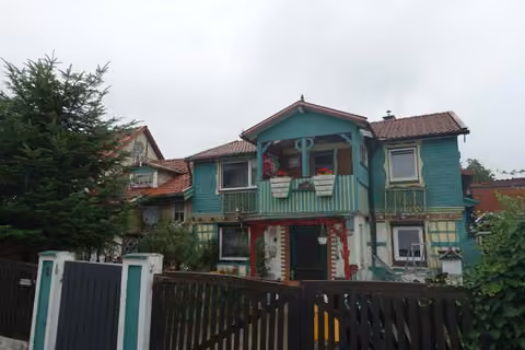 Zwangsversteigerung Einfamilienhaus in Harztor, Niedersachswerfen – Straßenansicht des zweigeschossigen Fachwerk-Wohnhauses mit bunt gestrichener Fassade und Vorgarten.