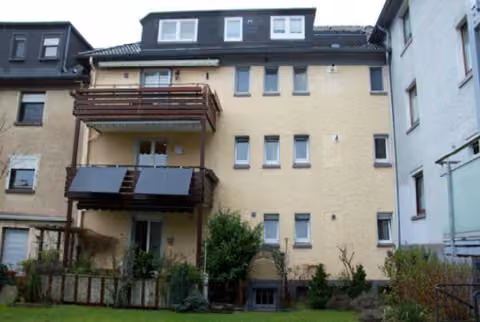 Zwangsversteigerung Eigentumswohnung in Essen, Bochold – Gartenansicht des Gebäudes mit Balkonen und Terrasse.