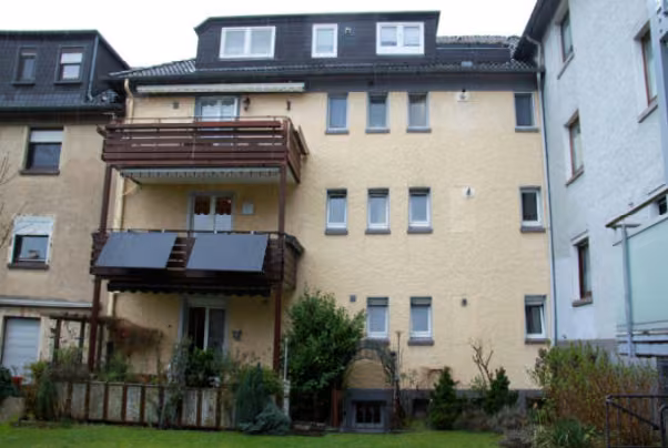 Zwangsversteigerung Eigentumswohnung in Essen, Bochold – Gartenansicht des Gebäudes mit Balkonen und Terrasse.