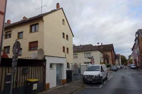 Zwangsversteigerung Eigentumswohnung in Frankfurt am Main, Griesheim – Straßenansicht Süd- und Ostfassade des Mehrfamilienhauses.