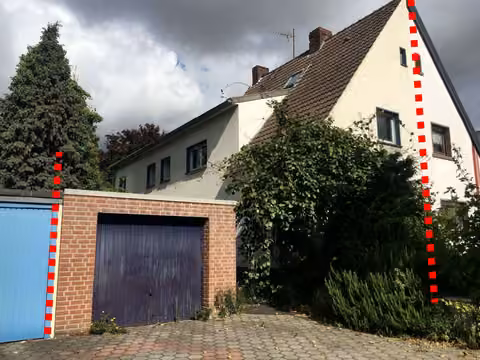 Zwangsversteigerung Doppelhaushälfte in Ahlen – Fassade Süd und West mit Garage und straßenseitigem Außenbereich.