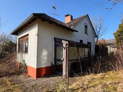 Zwangsversteigerung Einfamilienhaus in Lemgo, Brake – Vorderansicht des Einfamilienhauses mit verwildertem Garten.