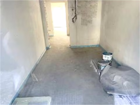 Zwangsversteigerung Eigentumswohnung in Wermelskirchen – Innenansicht der Wohnung Nr. 1 im Rohbauzustand, durch das Fenster fotografiert.