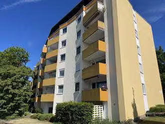 Zwangsversteigerung Eigentumswohnung in Bielefeld, Sennestadt – Südwestfassade des Mehrfamilienhauses Wintersheide 4 mit Balkonen und Wohnungsmarkierung.