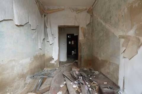 Zwangsversteigerung Mehrfamilienhaus in Oschersleben – Eingeschränkter Einblick in das beschädigte Gebäudeinnere.