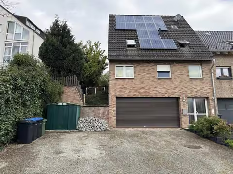 Zwangsversteigerung Doppelhaushälfte in Langerwehe – Vorderansicht des Hauses mit integrierter Garage an der Straßenseite.