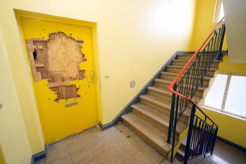 Zwangsversteigerung Wohn-/Geschäftshaus in Berlin, Schmargendorf – Zerstörte und notdürftig reparierte Wohnungstür im Neubau.