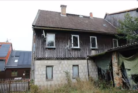 Zwangsversteigerung Einfamilienhaus in Oberharz am Brocken, Benneckenstein – Hofseitige Ansicht des Wohnhauses mit verwildertem Grundstück.