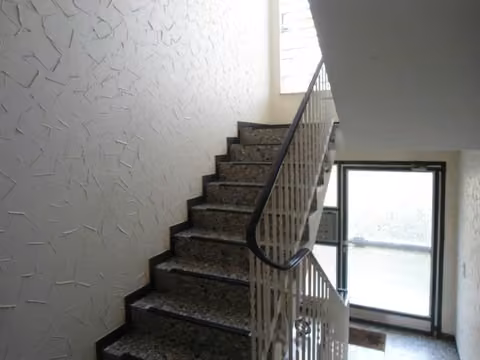 Zwangsversteigerung Mehrfamilienhaus in Löhne, Gohfeld – Innenansicht des Treppenhauses mit Massivtreppe.