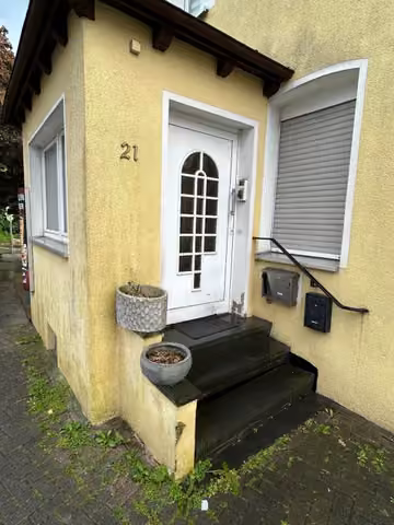 Zwangsversteigerung Wohn-/Geschäftshaus in Blomberg – Verandavorbau mit dem Haupteingang und den Eingangsstufen.