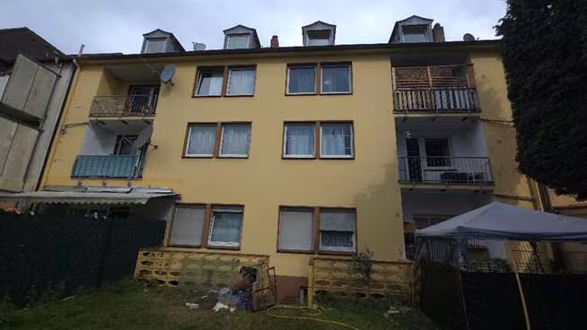 Zwangsversteigerung Eigentumswohnung in Gelsenkirchen, Schalke – Gebäuderückseite mit Vermüllung im hinteren Grundstücksbereich.